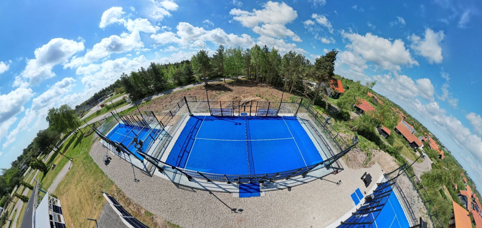 Blåt bassin og skov set som panorama