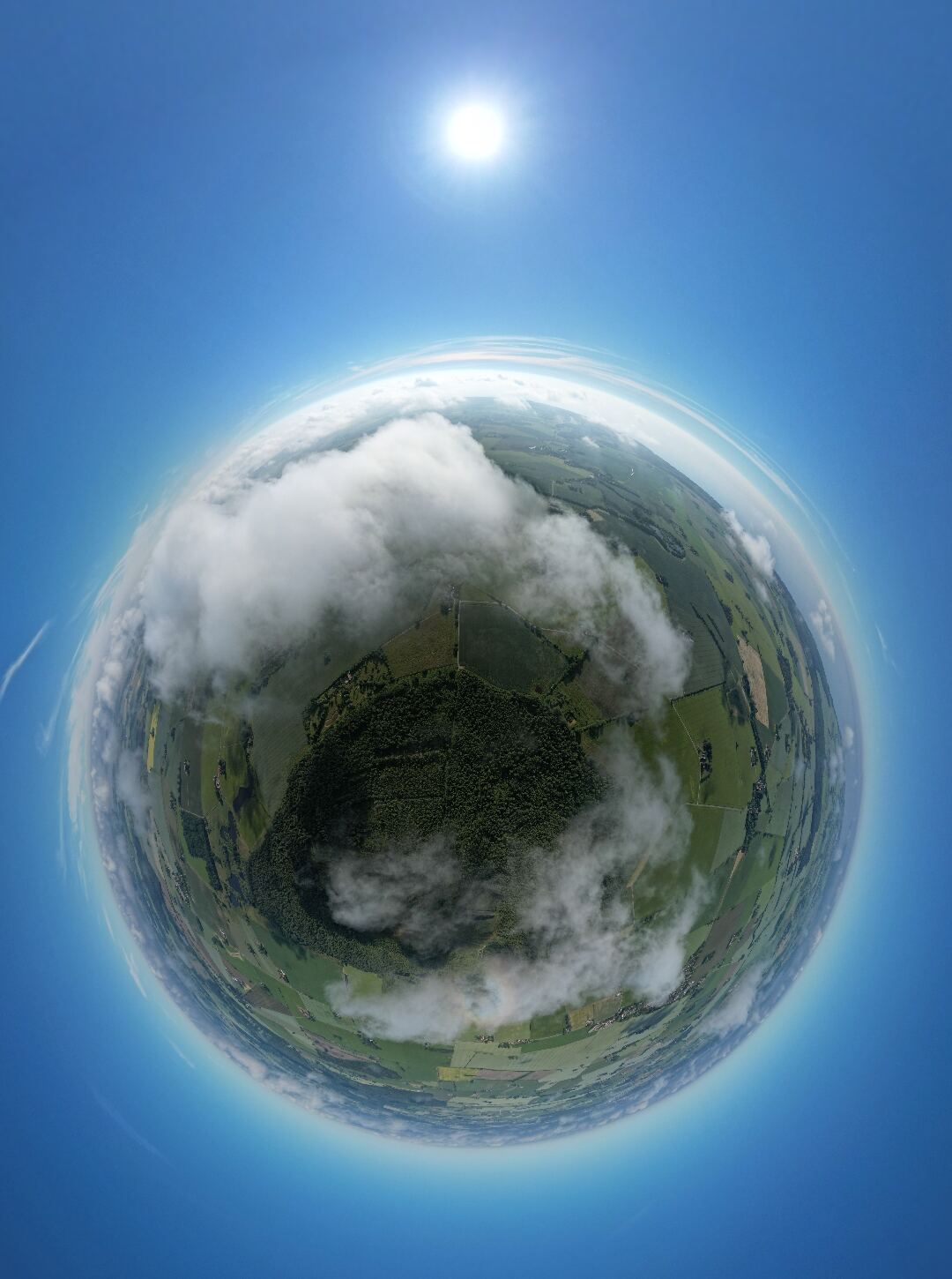 Landskab under skyer formet som en Tiny Planet